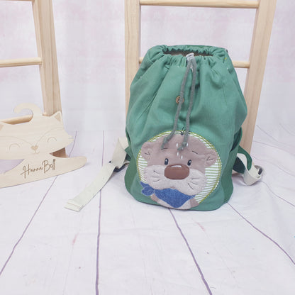 KIndergartenrucksack in Grüntönen mit Otterapplikation. Der Rucksack kann personalisiert werden. Ein Wunschname ist inklusive.