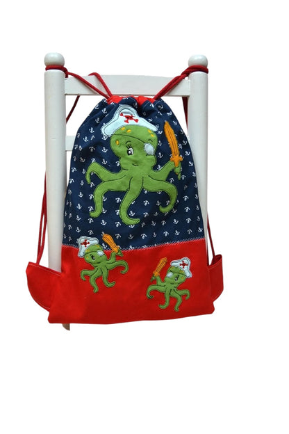 Turnbeutel aus Baumwollcanvas in Blau und Rot mit niedlichem Kraken-Motiv und Ankerdetails, optional personalisierbar mit einem Wunschnamen.