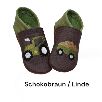 Lederpuschen für Kinder in Schokobraun und Linde mit farbenfrohem Trecker-Motiv und Anhänger, gefertigt aus hochwertigem Ökoleder und auf Wunsch personalisierbar.